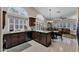 Kitchen with granite countertops, dark cabinetry, arched windows, and an adjacent dining area at 18730 N 89Th Ave, Peoria, AZ 85382