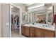 Bathroom with a spacious countertop, wood cabinets, and a walk-in closet with shelves for storage at 19503 N 142Nd Dr, Sun City West, AZ 85375