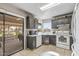 Efficient kitchen featuring gray cabinets, white appliances, and direct access to an outdoor covered patio at 19503 N 142Nd Dr, Sun City West, AZ 85375