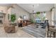 Comfortable living room featuring vaulted ceilings, tile flooring, a ceiling fan, and a large window for natural light at 19503 N 142Nd Dr, Sun City West, AZ 85375