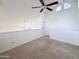 Bedroom featuring ceiling fan, arched windows, and neutral carpet flooring, offering a simple aesthetic at 19820 N 13Th Ave # 241, Phoenix, AZ 85027