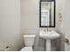 Modern powder room with pedestal sink, framed mirror, and toilet at 21052 N 58Th St, Phoenix, AZ 85054