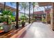 Exterior of a shopping center featuring storefronts, palm trees, and outdoor seating areas at 21052 N 58Th St, Phoenix, AZ 85054