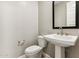 Powder room features a pedestal sink, modern faucet, and framed mirror at 21056 N 58Th St, Phoenix, AZ 85054