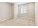 Bedroom has a large window, neutral paint color, carpet floors, and baseboards at 21056 N 58Th St, Phoenix, AZ 85054