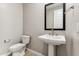 Elegant powder room featuring a pedestal sink, framed mirror, and light neutral walls at 21074 N 58Th St, Phoenix, AZ 85054