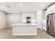 Open kitchen with a kitchen island with seating, white cabinetry, stainless steel appliances and light countertops at 21074 N 58Th St, Phoenix, AZ 85054