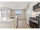 Open kitchen with a kitchen island with seating, stainless steel appliances and white countertops at 21074 N 58Th St, Phoenix, AZ 85054