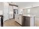 Open kitchen with a kitchen island with seating, white cabinetry, stainless steel appliances and light countertops at 21074 N 58Th St, Phoenix, AZ 85054