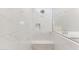 Luxurious shower with floor to ceiling marble, seating, and a built-in shelf at 21074 N 58Th St, Phoenix, AZ 85054