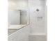 Modern bathroom featuring a glass-enclosed shower with marble tiling and a built-in niche, bench and double vanity at 21122 N 58Th St, Phoenix, AZ 85054