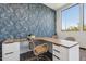 Elegant office with custom desk and unique accent wall providing a refined workspace bathed in natural light from a large window at 21122 N 58Th St, Phoenix, AZ 85054