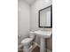 Powder room with pedestal sink, modern mirror, and toilet at 21126 N 58Th St, Phoenix, AZ 85054