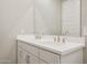 Bathroom featuring dual sinks with light countertop, large mirror, and brushed nickel fixtures at 21126 N 58Th St, Phoenix, AZ 85054