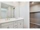 Bathroom featuring dual sinks with quartz countertop, large mirror and view of closet at 21126 N 58Th St, Phoenix, AZ 85054