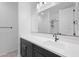 Modern bathroom featuring a mirror, white countertop, dark cabinets, and shower at 24267 W Gibson Ln, Buckeye, AZ 85326