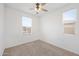 Clean bedroom with carpet, neutral walls, ceiling fan, and natural light from two windows at 24267 W Gibson Ln, Buckeye, AZ 85326