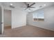 Light-filled bedroom with a ceiling fan, plush carpeting, and view of the bedroom entrance at 24267 W Gibson Ln, Buckeye, AZ 85326