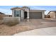 Charming single-story home with desert landscaping, brick driveway, and an attached two-car garage at 24267 W Gibson Ln, Buckeye, AZ 85326