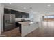 Modern kitchen with stainless steel appliances, granite countertops, and an island with sink at 24267 W Gibson Ln, Buckeye, AZ 85326