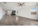 Bright living space featuring an open floor plan connecting kitchen and living areas, with wood-look floors at 24267 W Gibson Ln, Buckeye, AZ 85326