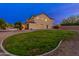 Spacious backyard featuring a lush lawn, mature trees, and a sparkling pool at twilight at 2448 E Amber Ct, Gilbert, AZ 85296