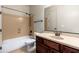 Bathroom featuring a shower-tub combo, wood cabinets, and tile floors at 2448 E Amber Ct, Gilbert, AZ 85296