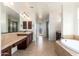 Well-lit bathroom featuring double sinks, a vanity area, and a luxurious soaking tub for ultimate relaxation at 2448 E Amber Ct, Gilbert, AZ 85296