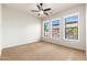 Bright, carpeted bedroom with neutral walls, a ceiling fan, and large windows offering plenty of natural light at 2448 E Amber Ct, Gilbert, AZ 85296