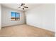 Empty bedroom featuring a ceiling fan, tan carpet, and a window at 2448 E Amber Ct, Gilbert, AZ 85296