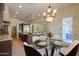 Bright dining area next to the kitchen features a modern chandelier and glass table at 2448 E Amber Ct, Gilbert, AZ 85296