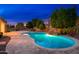 Backyard pool with a rock waterfall and travertine decking at 2448 E Amber Ct, Gilbert, AZ 85296