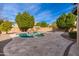 Backyard with a large pool, mature trees, a rock waterfall, and ample patio space at 2448 E Amber Ct, Gilbert, AZ 85296