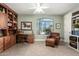 Well-lit home office featuring built-in bookshelves, a comfortable chair, and a large window at 2467 E Page Ave, Gilbert, AZ 85234