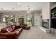 Cozy living room featuring a fireplace, large windows with backyard view, and comfortable seating at 2467 E Page Ave, Gilbert, AZ 85234