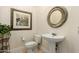 Charming powder room with pedestal sink, decorative mirror, and elegant wall art at 2467 E Page Ave, Gilbert, AZ 85234