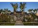 Well-maintained community center flanked by mature palm trees and lush landscaping at dusk at 2468 W Rowel Rd, Phoenix, AZ 85085