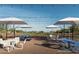 Outdoor seating area with cafe tables, chairs, umbrellas, and string lights at 2468 W Rowel Rd, Phoenix, AZ 85085