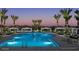 Luxurious community pool illuminated in the twilight, lined with palms and private cabanas at 2468 W Rowel Rd, Phoenix, AZ 85085