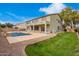 Backyard featuring a pool, green lawn, and desert landscaping at this lovely home at 2873 E Nolan Pl, Chandler, AZ 85249