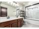 Bathroom featuring a double vanity sink with a large mirror, and a walk-in shower with decorative tiles at 2873 E Nolan Pl, Chandler, AZ 85249