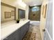 Bathroom featuring dual sinks, gray vanity, decorative mirrors and a tiled shower at 29810 W Bellview St, Buckeye, AZ 85396