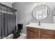 Bathroom featuring a dark toilet and vanity with a round mirror above the sink at 29997 N 70Th Dr, Peoria, AZ 85383