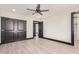 Spacious bedroom featuring hardwood floors, ceiling fan, closet, and ensuite bathroom access at 3102 W Desert Cove Ave, Phoenix, AZ 85029