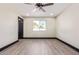 Bright bedroom with a window, ceiling fan, light hardwood floors, and white walls at 3102 W Desert Cove Ave, Phoenix, AZ 85029