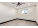 Bright bedroom featuring light hardwood floors, ceiling fan, and a window with view at 3102 W Desert Cove Ave, Phoenix, AZ 85029