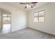 Bedroom features a ceiling fan, plush carpet, and a window allowing in natural light with views of the neighborhood at 35030 N Barzona Trl, San Tan Valley, AZ 85143