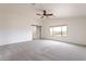 Expansive bedroom featuring a modern ceiling fan, new carpet, and a sliding barn door leading to bathroom at 35030 N Barzona Trl, San Tan Valley, AZ 85143