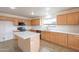 Bright kitchen featuring an island, stainless steel appliances and light wood cabinets at 35030 N Barzona Trl, San Tan Valley, AZ 85143