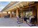 Covered patio with chairs and tables overlooking the yard, perfect for relaxation and entertaining at 3768 N 162Nd Ln, Goodyear, AZ 85395